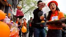 Seorang gadis menjual cupcakes oranye di sebuah stan pada Hari Ulang Tahun Raja atau King's Day di Amsterdam, 27 April 2018. Hari Raja diselenggarakan untuk merayakan hari ulang tahun raja Belanda, Raja Willem Alexander. (AP/Peter Dejong)