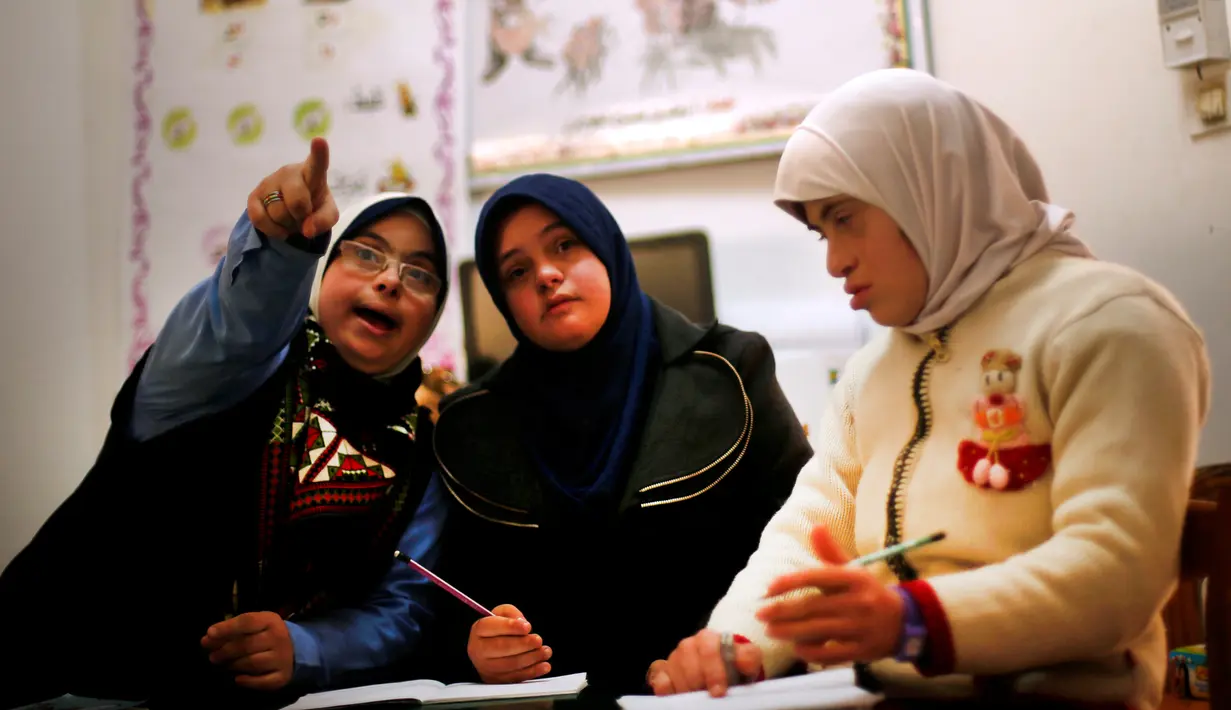 Hiba Al-Sharfa mengajar muridnya yang menderita Down Syndrome di sekolah Asosiasi Hak Hidup di Kota Gaza (21/12). Hiba berhasil mencapai mimpinya dengan menjadi guru pertama pengidap Down Syndrome. (Reuters/Suhaib Salem)