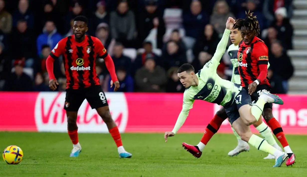 Pemain Manchester City Phil Foden (kanan depan) berduel memperebutkan bola dengan pemain Bournemouth Jordan Zemura pada pertandingan sepak bola Liga Inggris di Vitality Stadium, Bournemouth, Inggris, 25 Februari 2023. Manchester City mengalahkan Bournemouth dengan skor 4-1. (AP Photo/David Cliff)