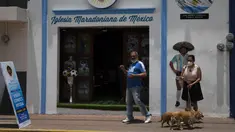 Turis berfoto di depan Gereja Maradona di San Andres Cholula, negara bagian Puebla, Meksiko, Minggu (18/7/2021). Gereja Maradona di Meksiko didedikasikan untuk mendiang legenda sepak bola asal Argentina Diego Armando Maradona. (AP Photo/Marco Ugarte)