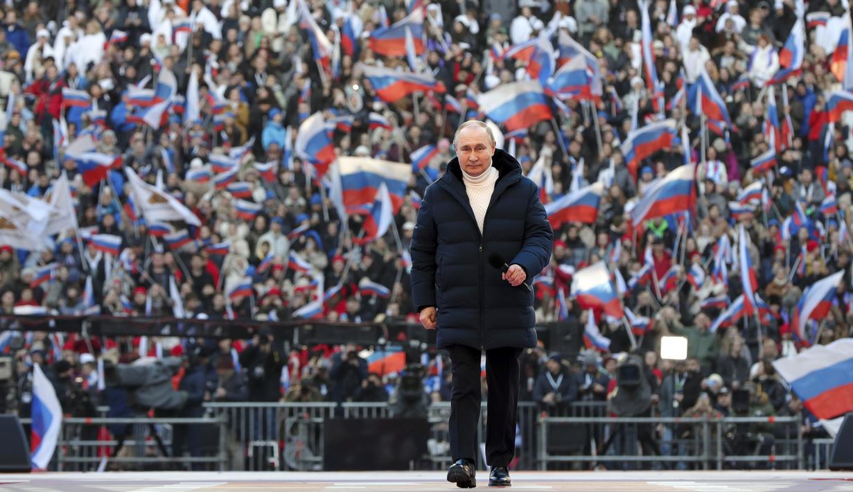 Presiden Rusia Vladimir Putin tiba untuk menyampaikan pidatonya di konser perayaan  delapan tahun referendum tentang status negara bagian Krimea dan Sevastopol serta penyatuannya kembali dengan Rusia, di Moskow, Rusia (18/3/2022). (Mikhail Klimentyev, Sputnik, Kremlin Pool Photo via AP)
