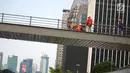 Pekerja menyelesaikan revitalisasi Jembatan Penyeberangan Orang (JPO) Gelora Bung Karno (GBK), Jakarta, Selasa (27/11). Pembangunan tiga JPO Polda Metro Jaya, GBK dan Bundaran Senayan menelan Rp56 miliar. (Liputan6.com/Faizal Fanani)