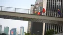 Pekerja menyelesaikan revitalisasi Jembatan Penyeberangan Orang (JPO) Gelora Bung Karno (GBK), Jakarta, Selasa (27/11). Pembangunan tiga JPO Polda Metro Jaya, GBK dan Bundaran Senayan menelan Rp56 miliar. (Liputan6.com/Faizal Fanani)