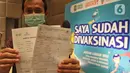 Seorang pria menunjukkan kartu vaksinasi Covid-19 di Ballroom Novotel Tangerang, pada Senin,(1/3/2021). Pelaksanaan vaksinasi Covid-19 tersebut digelar Dinas Kesehatan Kota Tangerang. (merdeka.com/Arie Basuki)