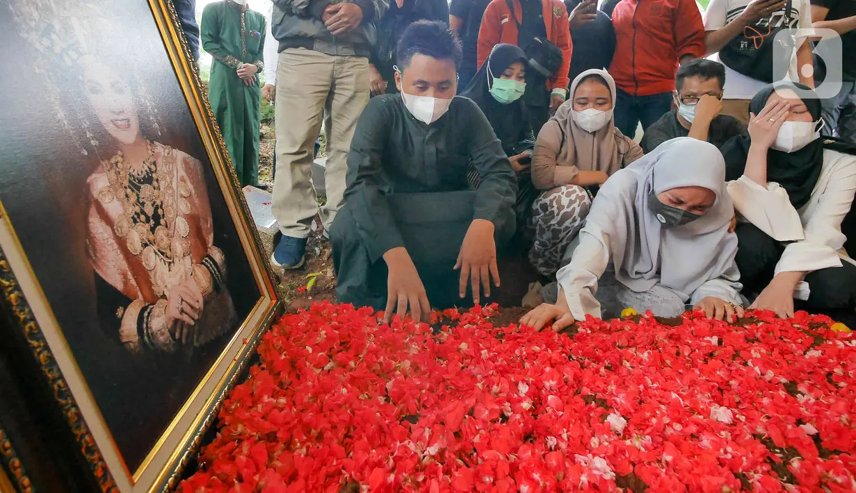 Kerabat dan keluarga berdoa di makam Dedi Yuliardi Ashadi atau Dorce Gamalama di TPU Bantar Jati, Bambu Apus, Jakarta, Rabu  (16/2/2022). Dorce menghembuskan nafas terakhir di RSPP Simprug, Jakarta Selatan, Rabu (6/2) pukul 07.00 WIB. (Liputan6.com/Herman Zakharia)