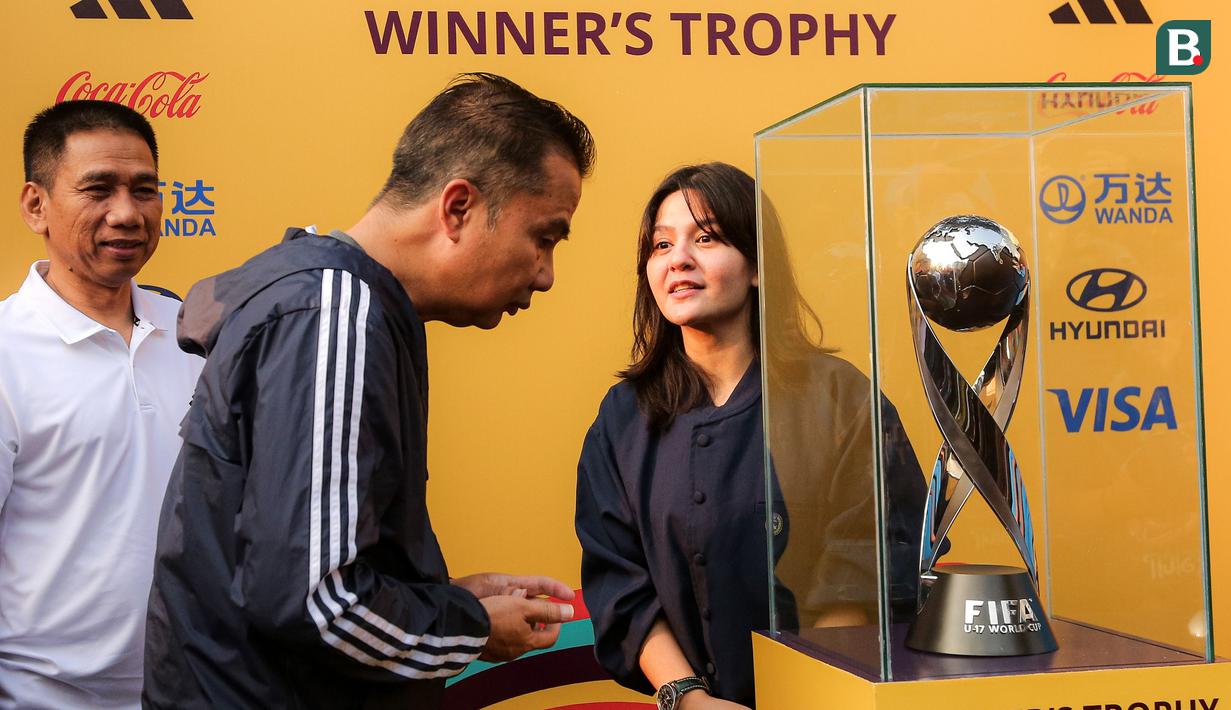 Pj Gubernur Jawa Barat, Bey Machmudin (tengah) didampingi Waketum PSSI, Ratu Tisha mengamati trofi Piala Dunia U-17 dalam rangkaian acara Trophy Tour Experience menyambut Piala Dunia U-17 2023 di Cikapayang Dago Park, Bandung, Minggu (22/10/2023) pagi WIB. (Bola.com/Bagaskara Lazuardi)