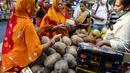 Dua wanita membeli kelapa di pinggir jalan menjelang festival Hindu Chhath, di Kolkata, India (9/11/2021). Selama Chhath, festival Hindu kuno yang populer di kalangan kelas pekerja, ritual dilakukan untuk berterima kasih kepada Dewa Matahari atas menopang kehidupan di bumi. (AP Photo/Bikas Das)