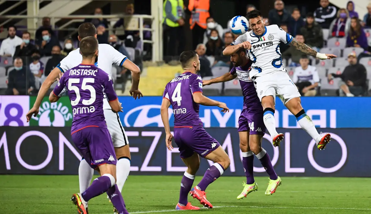 Penyerang Inter Milan Lautaro Martinez (kanan) dan gelandang Fiorentina Marco Benassi menyundul bola pada pekan kelima Liga Italia Serie A 2021/2022 di Artemio Franchi, Rabu (22/9/2021) dini hari WIB. Inter Milan menang 3-1 meski sempat tertinggal lebih dulu di babak pertama. (ANDREAS SOLARO / AFP)