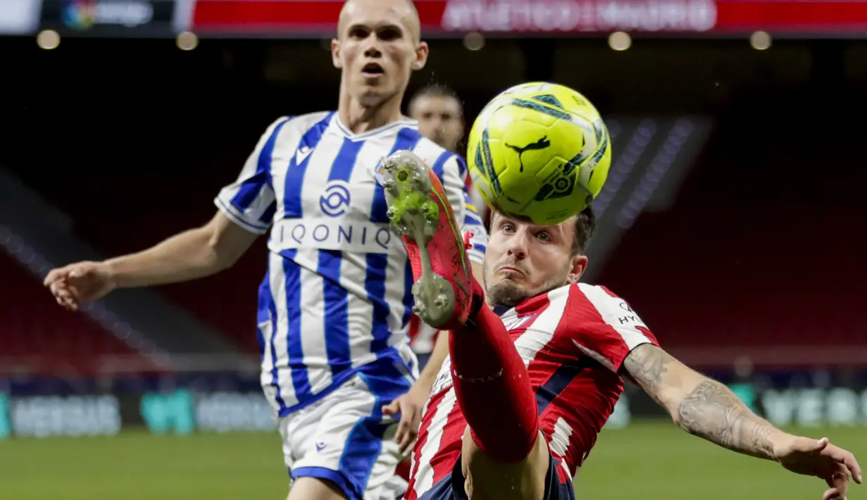 Gelandang Atletico Madrid, Saul Niguez (depan) mengontrol bola saat melawan Real Sociedad dalam laga lanjutan Liga Spanyol 2020/2021 pekan ke-36 di Wanda Metropolitano Stadium, Rabu (12/5/2021). Atletico menang 2-1 atas Sociedad. (AP/Bernat Armangue)
