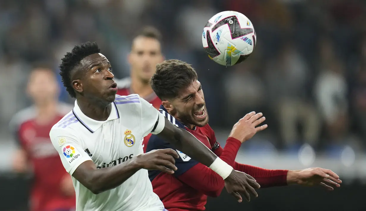 Penyerang Real Madrid Vinicius Junior berebut bola dengan bek Osasuna Nacho Vidal  pada pekan ketujuh Liga Spanyol 2022/2023 di Stadion Santiago Bernabeu, Senin dini hari WIB (3/10/2022). Langkah Real Madrid melanjutkan trend kemenangan di Liga Spanyol 2022/2023 terhenti di pekan ketujuh. (AP Photo/Manu Fernandez)