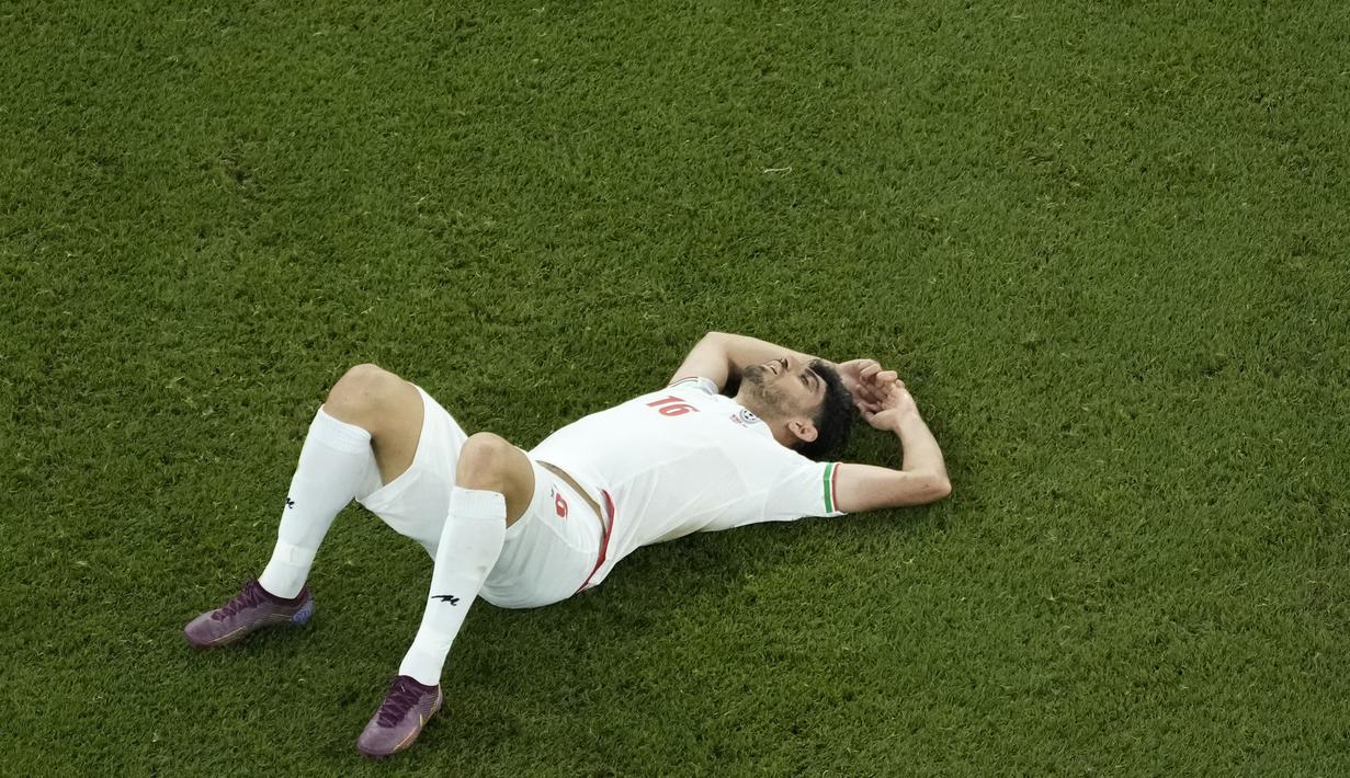 Pemain Iran, Mehdi Torabi, terbaring lesu usai ditaklukkan Amerika Serikat pada laga Grup B Piala Dunia di Stadion Al Thumama, Doha, Selasa (29/22/2022). (AP/Hassan Ammar)