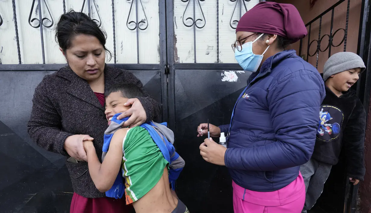 Reaksi seorang anak sebelum divaksinasi COVID sambil dipeluk ibunya, di Quito, Ekuador, 26 Januari 2022. Brigade campuran dari pemerintah kota dan Kementerian Kesehatan mengunjungi lingkungan miskin untuk mendeteksi kasus COVID-19 dan melakukan vaksinasi. (AP Photo/Dolores Ochoa)