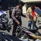 Anggota polisi menggeledah motor tamu pengunjung yang datang ke Mapolda Jawa Tengah, Kota Semarang, Senin (14/5).Tak ingin kecolongan, Mapolda Jateng memperketat pengamanan menyusul aksi teror bom yang bertubi-tubi. (Liputan6.com/Gholib)