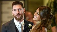Ekspresi Lionel Messi  bersama istrinya Antonella Roccuzzo  usai melangsungkan pernikahan di Rosario, provinsi Santa Fe, Argentina (30/6). Dalam acara itu turut hadir Luis Suarez, Angel di Maria, Xavi Hernandez dan lainnya. (AFP Photo/Eitan Abramovich)