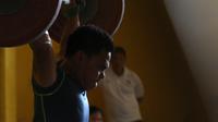 Atlet Angkat Besi Indonesia, Eko Yuli sedang berlatih dekat halaman Parkir Angkat Besi di Senayan, Jakarta, Senin (11/1/2016). Latihan diluar dilakukan karena tempat latihan biasanya dalam tahap renovasi. (Bola.com/Nicklas Hanoatubun)