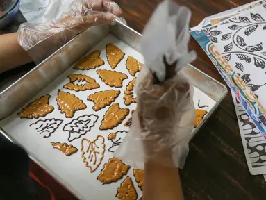 Pengusaha kue rumahan, Diyah Maryatini mewarnai kue batik di Dapur Syabina, Pamulang Barat, Tangerang Selatan, Minggu (4/10/2020). Usaha kue batik yang digeluti sejak tahun 2019 mampu memproduksi 10 hingga 12 bolu dan brownies bermotif batik. (Liputan6.com/Fery Pradolo)