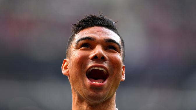 Gelandang Real Madrid , Casemiro berselebrasi usai mencetak gol ke gawang Atletico de Madrid pada pertandingan lanjutan La Liga Spanyol di stadion Wanda Metropolitano (9/2). Real Madrid menang 3-1 atas Atletico. (AFP Photo/Gabriel Bouys)