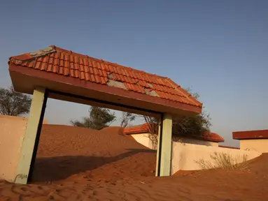Pintu masuk sebuah rumah yang setengah terkubur di gurun pasir, di desa terlantar Al-Madam, berbatasan dengan Emirat Teluk Sharjah, Kamis (22/4/2021). Al Madam adalah sebuah kota kecil berjarak 60 kilometer dari kota Dubai yang terlantar ditinggalkan sejak lama oleh penduduknya (GIUSEPPE CACACE/AFP