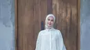 Penampilan anggun Paula dengan lace maxi dress berwarna putih yang dipadukan hijab dengan motif minimalis. [@paula_verhoeven]