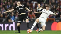  Gelandang Ajax, Donny van de Beek (kiri) berebut bola dengan gelandang Real Madrid, Donny van de Beek pada laga leg kedua babak 16 besar Liga Champions di stadion Santiago Bernabeu, Madrid pada 5 Maret 2019. Manchester United resmi memboyong van de Beek dari Ajax. (AFP/Gabriel Bouys)