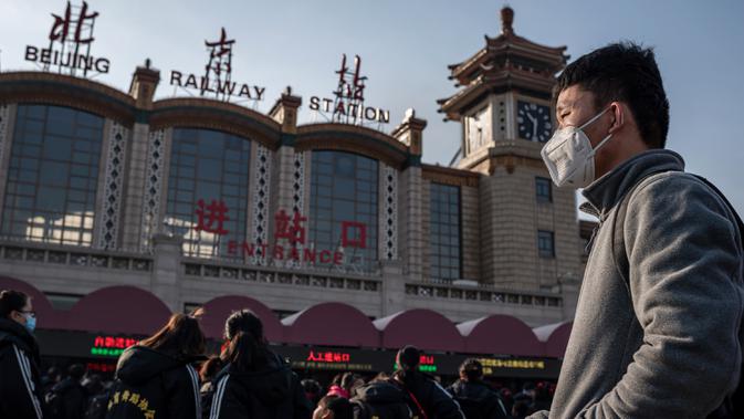Orang-orang mengenakan masker penutup mulut saat menuju stasiun kereta api Beijing untuk mudik Tahun Baru Imlek pada Selasa (21/1/2020). Virus mirip SARS yang menyebar ke seluruh wilayah China dan mencapai tiga negara Asia ternyata dapat menular dari satu orang ke orang lain. (NICOLAS ASFOURI/AFP)