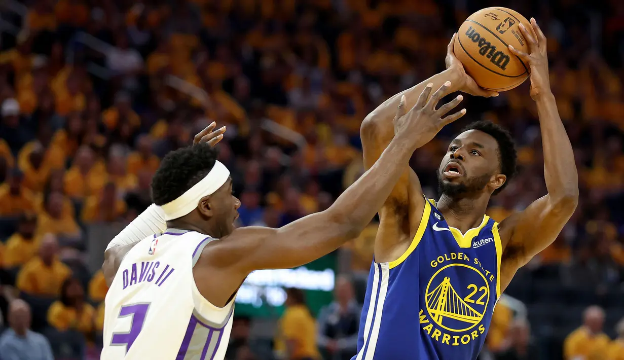 Pebasket Golden State Warriors, Andrew Wiggins (kanan) berusaha menembakkan bola dibayangi pebasket Sacramento Kings, Terence Davis saat putaran pertama NBA Playoff di Chase Center, San Francisco, California, 28 April 2023. Wiggins akan menjadi salah satu kekuatan Kanada untuk mentas dari Grup H Piala Dunia Basket 2023 di Indonesia. (AFP/Getty Images/Ezra Shaw)