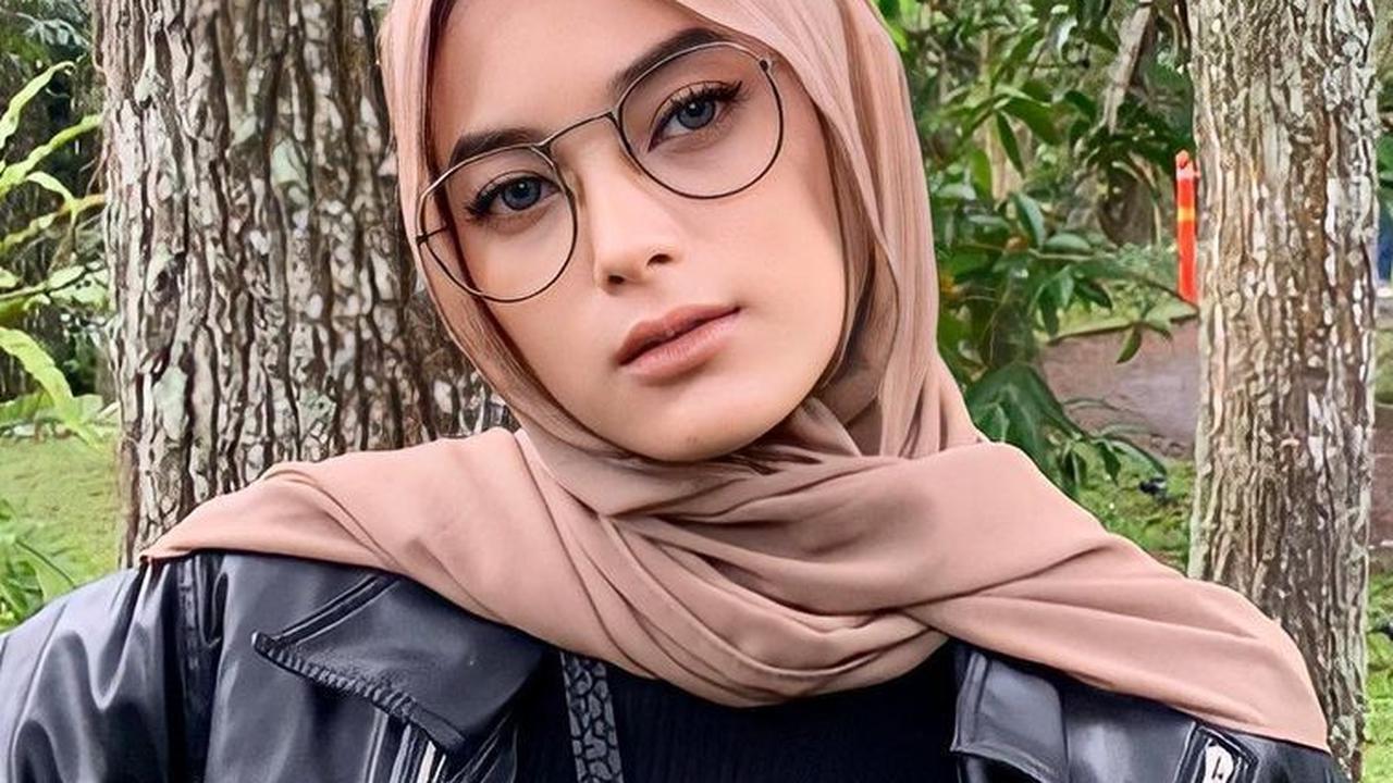 Penampilan Syalma saat berhijab ini berhasil membuat pangling metizen. Meski berpenampilan tertutup, gayanya terlihat elegan dengan jaket kulit warna hitam.