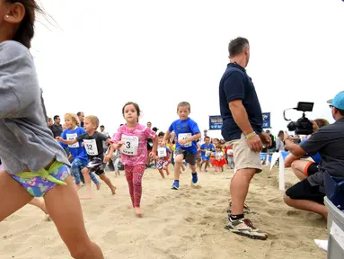 Sejumlah anak saat berpartisipasi dalam 'Tot Trot' selama Nautica Malibu Triathlon di Pantai Zuma di Malibu, California (14/9). (Noel Vasquez / Getty Images untuk Nautica / AFP)