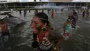 Sejumlah orang dari suku asli Brasil menceburkan diri di kolam gedung Kongres Nasional saat menggelar aksi, Brasilia, Brasil (25/4). Mereka berusaha menyelamatakan diri dari tembakan gas air mata dengan menceburkan diri ke kolam. (AP Photo/Eraldo Peres)