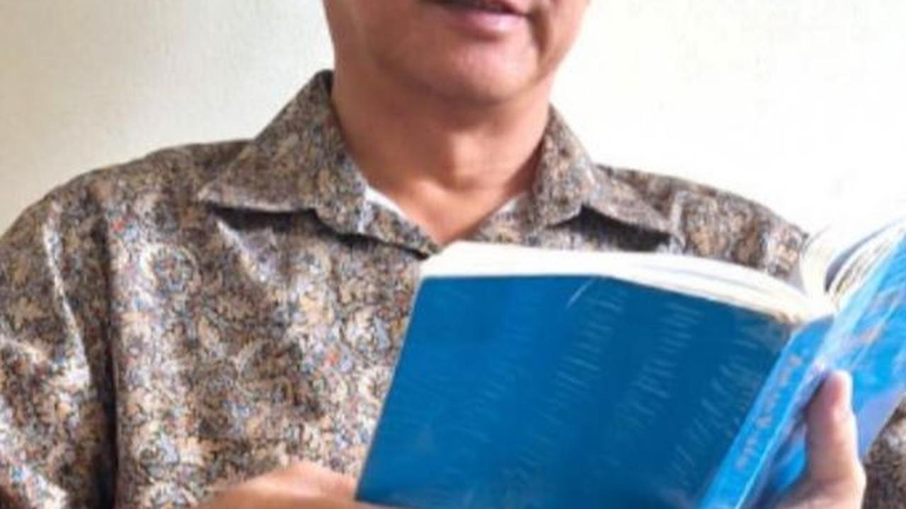 Ronald sedang Membaca buku Zhuan Falun