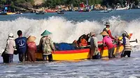 Sejumlah nelayan mendorong perahu di Pantai Sidem, Jatim. Tingginya ombak menyebabkan nelayan tidak melaut sehingga harga ikan naik rata-rata Rp 1.000 - Rp 3.000 per kg.(Antara)