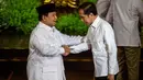 Presiden Republik Indonesia Prabowo Subianto (kiri), yang juga Ketua Umum Partai Gerakan Indonesia Raya (Gerindra), dan Presiden Republik Indonesia ke-7 Joko Widodo saling menyapa di atas panggung pada puncak perayaan ulang tahun ke-17 Partai Gerindra di Sentul International Convention Center (SICC), Bogor, Jawa Barat, Sabtu (15/2/2025). (ADITYA AJI/AFP)