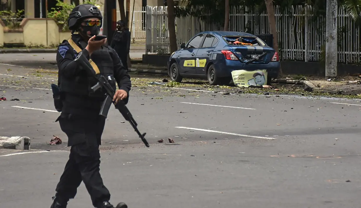 Polisi memeriksa lokasi di dekat sebuah gereja setelah ledakan di Makassarr (28/3/2021).   Polisi menduga ledakan terjadi akibat bom bunuh diri. (AFP/Indra Abriyanto)
