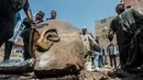 Warga melihat dekat pecahan patung yang ditemukan oleh tim arkeolog Jerman-Mesir di distrik Mattarya, Kairo, Kamis (9/3). Diduga pecahan patung yang digali di sekitar Kuil Ramses II tersebut berasal dari dinasti XIX (1295-1185 SM)