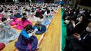 Siswa sekolah menengah atas yang mengenakan pakaian tradisional membungkuk kepada guru dan orangtua mereka saat upacara kelulusan dan kedewasaan bersama di Sekolah Menengah Wanita Dongmyung, Seoul, Korea Selatan, 7 Februari 2023. Sekolah menengah atas di Korea Selatan mengajar siswa selama tiga tahun, dari kelas satu (usia 15–16) hingga kelas tiga (usia 17–18), dan siswa biasanya lulus pada usia 17 atau 18 tahun. (AP Photo/Ahn Young-joon)