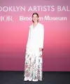 Rosamund Pike mengenakan jaket bordir wol putih Dior Cruise 2024 dengan gaun taffeta sutra putih. Dia juga memakai sepatu Dior. [Dior]