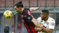 Striker AC Milan, Zlatan Ibrahimovic, berebut bola dengan pemain Torino, Gleison Bremer, pada laga Coppa Italia di Stadion San Siro, Selasa (12/1/2021). AC Milan menang adu penalti dengan skor 5-4. (AP/Antonio Calanni)
