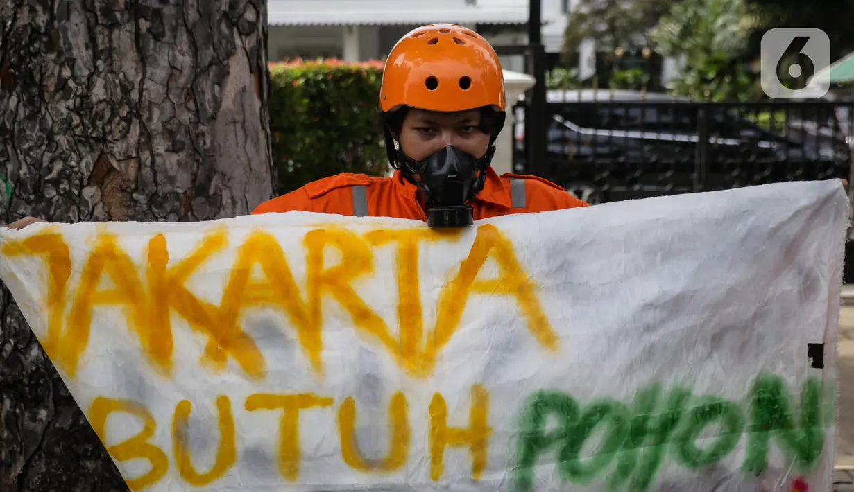 Aktivis Walhi membentangkan spanduk saat menggelar aksi terkait proyek revitalisasi kawasan Monas di depan Balai Kota DKI Jakarta, Kamis (30/1/2020). Selain minta dihentikan, mereka juga mendesak kawasan Monas dikembalikan ke fungsi awal sebagai ruang terbuka hijau. (Liputan6.com/Faizal Fanani)
