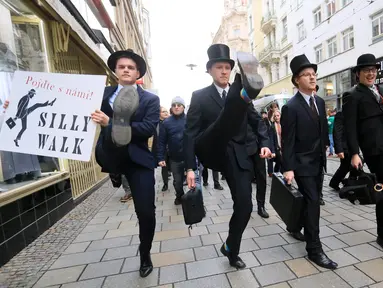 Sejumlah pria mengenakan kostum berjalan dengan mengangkat tinggi kakinya di Brno, Republik Ceko (7/1). Mereka berjalan dengan mengenakan kostum tersebut dalam acara International Silly Walk Day.  (AFP Photo/Radek Mica)