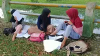 Para pelajar di Kecamatan Kinal, Kabupaten Kaur, Bengkulu harus belajar di tepi sungai karena sulitnya sinyal di desa mereka (Foto: Tomi Defantri).