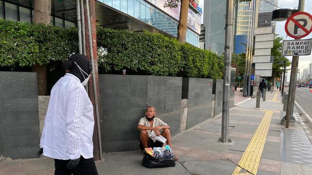 Menteri Sosial Tri Rismaharini atau Risma menyapa tunawisma di Jalan Sudirman, Jakarta Pusat, sebelum bekerja