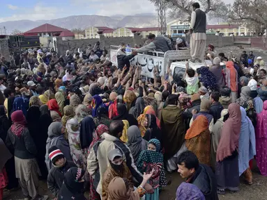 Orang-orang berdesak-desakan untuk membeli sekarung tepung terigu bersubsidi dari sebuah titik penjualan di Quetta, Pakistan, Kamis (12/1/2023). Orang-orang menderita akibat kenaikan harga tepung terigu di Pakistan baru-baru ini. (AP Photo/Arshad Butt)