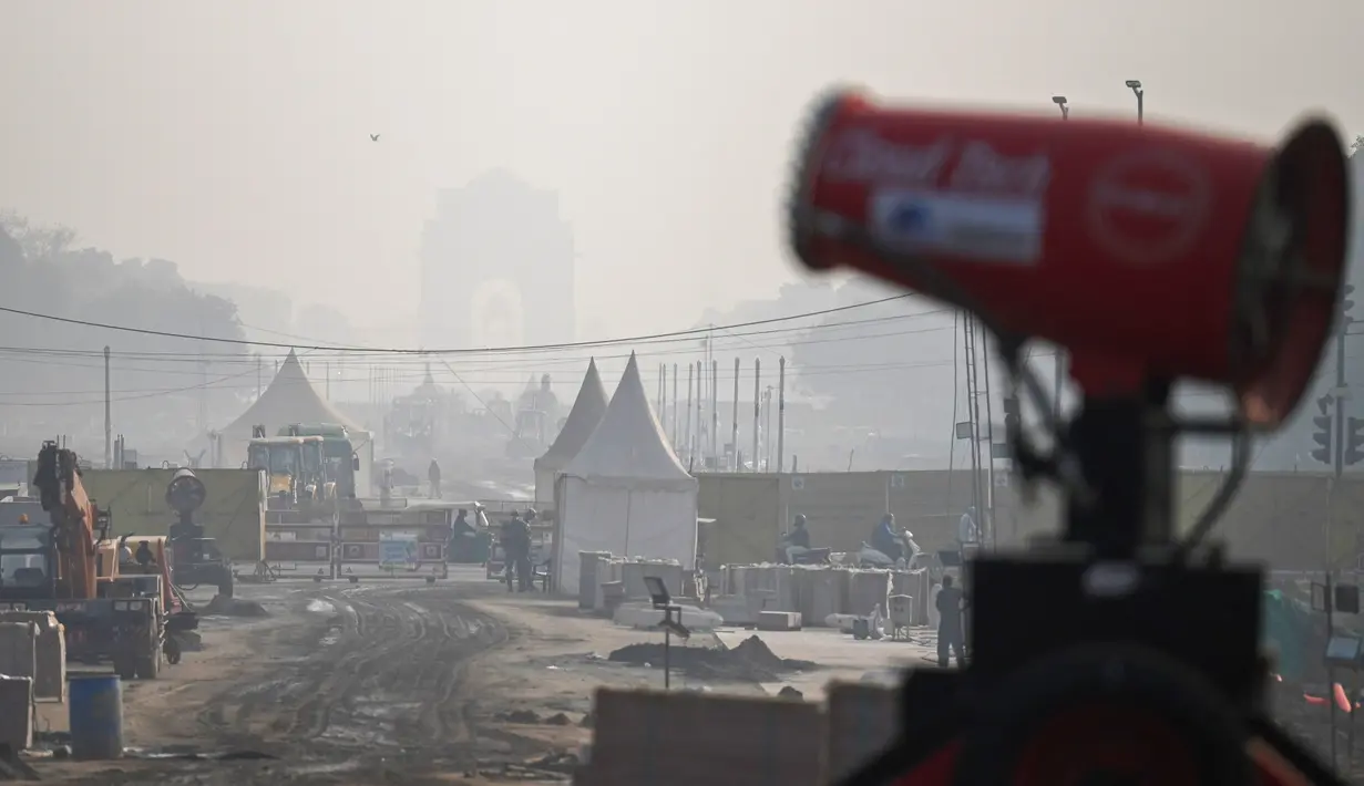 Komuter berjalan di sepanjang jalan di tengah kondisi kabut asap tebal di New Delhi (15/11/2021). India memutuskan untuk menutup sekolah di New Delhi selama sepekan dan berencana menerapkan lockdown untuk melindungi warganya. (AFP/Money Sharma)