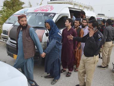 Polisi tiba bersama imigran Afghanistan yang ditahan di pusat deportasi, yang didirikan oleh pihak berwenang untuk memfasilitasi imigran ilegal, di Quetta, Pakistan, Rabu (1/11/2023). (AP Photo/Arshad Butt)