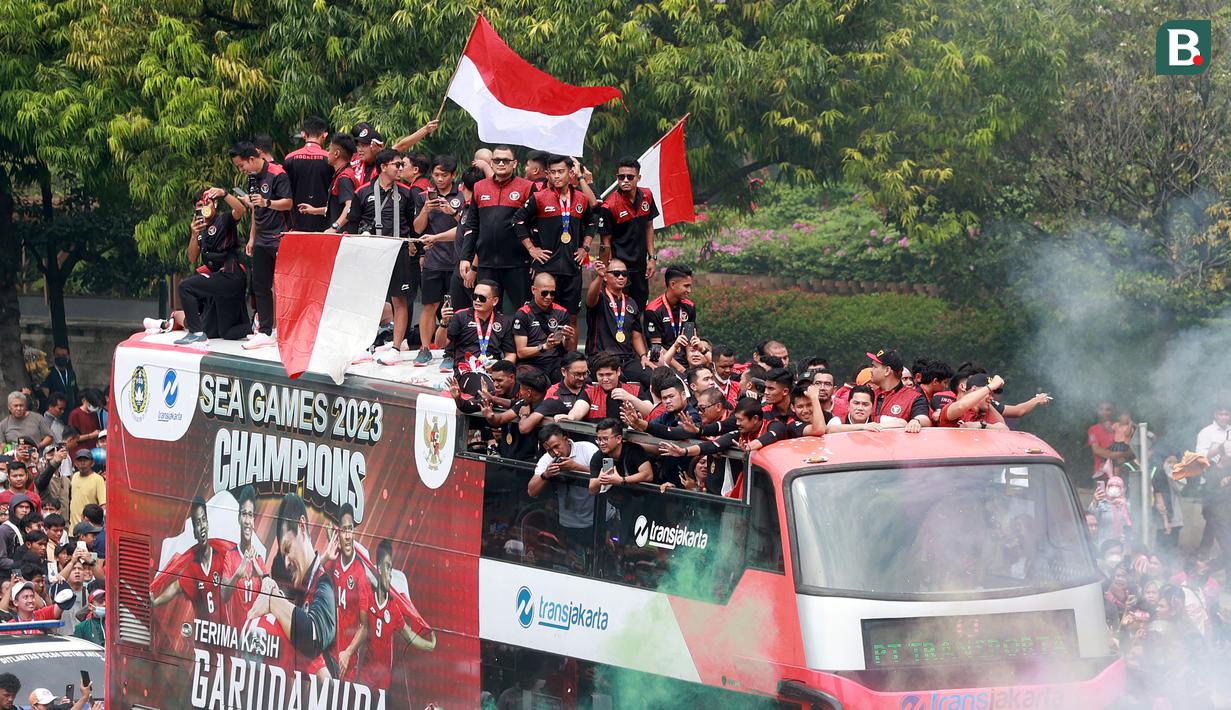 <p>Timnas sepak bola Indonesia U-22 bersama ofisial dan pengurus PSSI berada di atas bus saat melintas dalam arak-arakan Kira87uara Kontingen SEA Games 2023 di Bundaran HI, Jakarta, Jumat (19/5/2023). (Bola.com/M Iqbal Ichsan)</p>