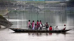Anak-anak sekolah naik perahu menyeberangi sungai Brahmaputra di desa Kasoshila di pinggiran Gauhati, India (21/10/2019). Brahmaputra adalah salah satu sungai terbesar di Asia, yang melewati wilayah Tibet China, India, dan Bangladesh sebelum konvergen ke Teluk Benggala. (AP Photo/Anupam Nath)