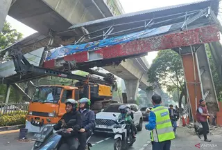 Sopir truk pengangkut alat berat yang tersangkut di Jembatan Penyeberangan Orang (JPO) Jalan Kapten Tendean arah Blok M, Mampang Prapatan, Jakarta Selatan, Andre (28), mengungkap penyebab insiden yang terjadi pada Selasa dini hari sekitar pukul 01.00 WIB. (Foto: Antara)