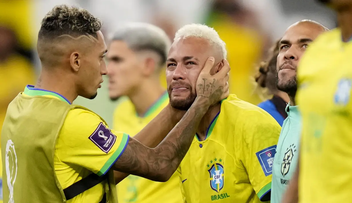Pemain Brasil, Neymar (kanan) dihibur oleh rekannnya, Raphinha setelah tim mereka kalah dari Kroasia saat laga perempat final Piala Dunia Qatar 2022 yang berlangsung di Education City Stadium, Al-Rayyan, Jumat (09/12/2022) waktu setempat. Brasil kalah 2-4 dari Kroasia saat babak adu penalti. (AP/Darko Bandic)