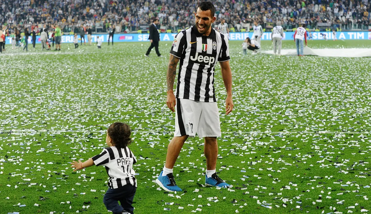 Carlos Tevez (kanan) bermain bersama anaknya di tengah perayaan gelar juara Serie A 2014-15 di Juventus Arena, Italia, (23/5/2015). Ini merupakan Gelar ke-31 Juventus di Serie A. (Reuters/Giorgio Perottino)
