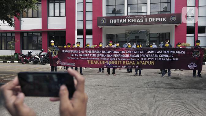 Narapidana foto bersama usai mendapat pembebasan bersyarat melalui program asimilasi dan integrasi terkait pandemi virus corona COVID-19 di Rutan Kelas I Depok, Jawa Barat, Selasa (7/4/2020). Narapidana yang dibebaskan harus sudah menjalani dua pertiga masa tahanan. (Liputan6.com/Johan Tallo)